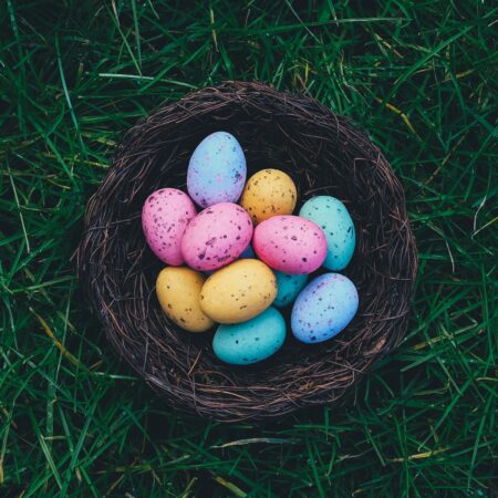 Multiple Colours of Mini Easter Eggs in a basket with grass underneath
